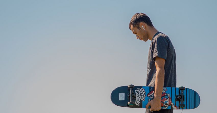 Negative Space - Man Holding A Skateboard