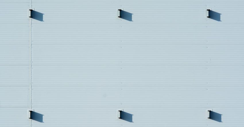 Minimalist Design - A close up of a blue wall with four holes