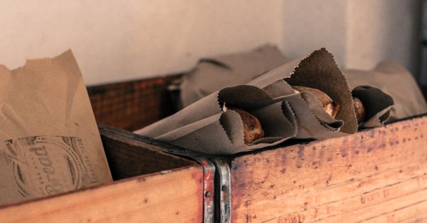 Food Packaging - Photograph of Food Packaged in Grey Kraft Paper Bags Placed in Brown Wooden Open Boxes